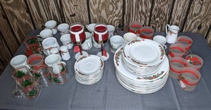 lot 250 image: Holiday Dining & Drinking Collection - Poinsettia & Ribbons Fine China Plate Sets, Vintage Waechtersbach Christmas Tree Coffee Mugs, Santa Wine Glasses, Holiday Cheer Tumblers, and more