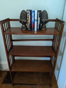 lot 30 image: 4-Shelf Folding Bookcase, Wooden Pine Cone Bookends, Books by Tom Clancy and John Grisham