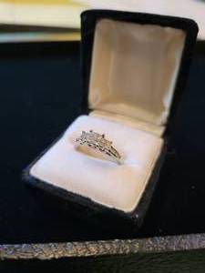 lot 89 image: 14K White Gold Ring. 3.9 grams with 8 round full cut channel set diamonds and 12 channel set princess diamonds. $3,500 appraisal.  Size 7.