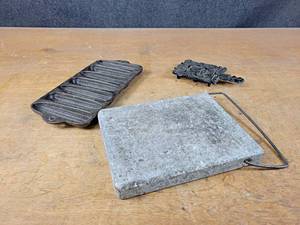 lot 1110 image: Cast Iron Cornbread Pan, Stone Cutting Board and Cast Iron WILTON Trivet