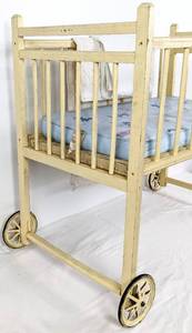 lot 175 image: 1926 Large Yellow Wooden Doll Crib on Wheels with Original Mattress and Pad