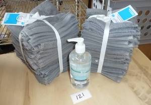 2 large stacks of 18 washcloths each, and a bottle of sanitizr