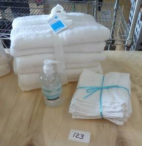 4 white bath towels, 4 wash cloths, bottle of hand sanitizer