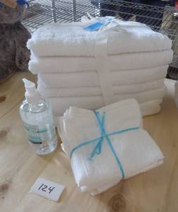 4 white bath towels, 4 wash cloths, bottle of hand sanitizer