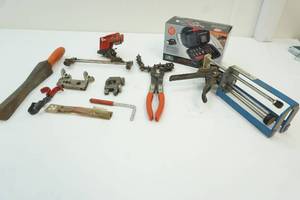 lot 118 image: chainsaw sharpener, pipe cutters and flaring rods, epoxy gun and flashlight toolkit
