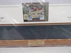 lot 33 image: Leinenkugels Frosty Winter By Scott Zoellick Signed by Scott Zoellick (illustrator) and by Jack Leinenkugel (President of Leinenkugel Brewing Co.) - Professionally Framed - Still In Plastic - FANTASTIC PIECE - APPROX 30 By 25 - SEE PICTURES