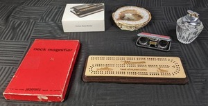 lot 189 image: Vintage Hoffritz Neck Magnifier, Custom MN Cribbage Board, Travellers Compact Binoculars, PowerMate Mini Cigarette Roller, Large Geode, and Princess House Crystal Table Lighter  X