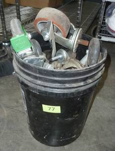 lot 77 image: 5 gallon pail full of industrial wheels for tables or carts