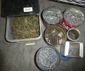 lot 245 image: 30 lb bucket of 16d 3-14 inch coated sinker nails basically full, plus a number of other cans of nails