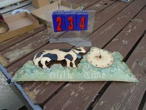 lot 234 image: Metal formed wall clock milk times. As shown.
