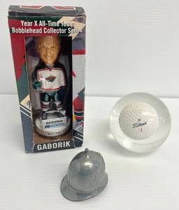 lot 152 image: Misc. Items Including Gaborik Bobblehead , DT Titleist Golf Ball Encasement In Clear Acrylic (Has Glowing Blue Halo Around Ball In Sunlight) And Mini metal Police Helmet -