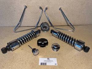 lot 21 image: Harley-Davidson Sportster Shocks, Gas Caps, Oil Cap, Saddlebag Gangers, and Speedometer Unit
