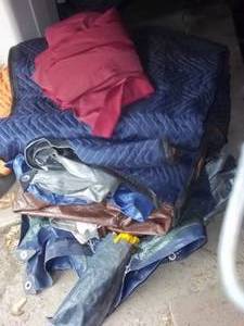 lot 93 image: Stack of assorted tarps in a variet...