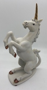 lot 339 image: Unicorn Collection - 1 Brass Unicorn, 2 Porcelain and Crystal Unicorn on a Mirrored Music Box