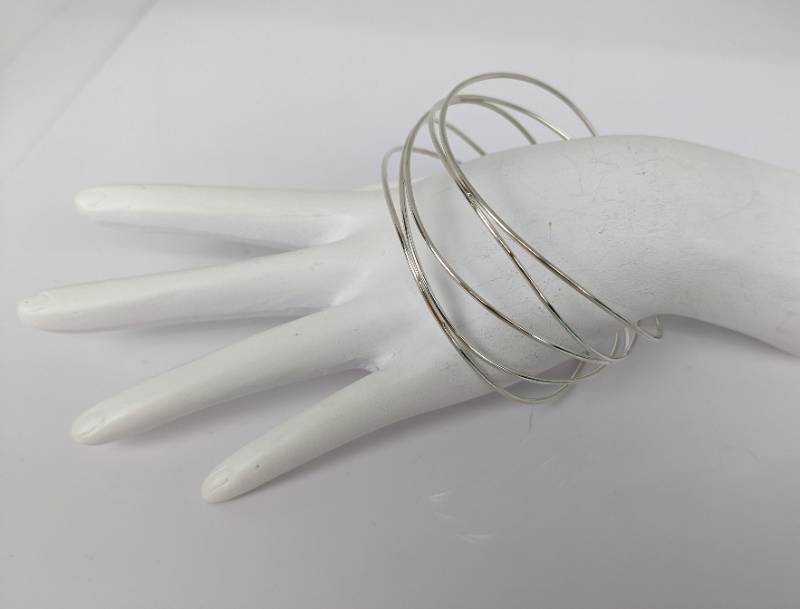 lot 142 image: Tiffany & Co. Sterling Elsa Peretti Wave 5-Row Bangle Bracelet, with Box and Pouch