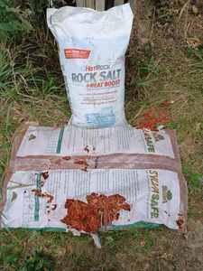lot 227 image: Ortho and Spectracide Products, Torn Bag of New Red Mulch, and a New Bag of Hot Rock Salt Heat Boost