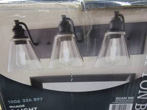 lot 609 image: Hampton Bay Manor 24 in. 3-Light Matte Black Industrial Bathroom Vanity Light with Clear Glass Shades (BOX DAMAGED, PRODUCT APPEARS UNAFFECTED)