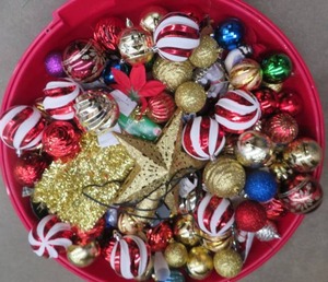 LG WREATH CONTAINER FILLED WITH DECORATIONS.
