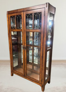 lot 29 image: MSRP $4500 Gorgeous High Quality Vintage Mission Arts & Crafts Style Glass Panel 2 Door Storage Cabinet - Inside Lights Up With a Touch To The Outside - Check out The Detail Work  Glass Shelves Intact Simply Stunning For Your Library