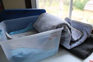lot 101 image: Clear Tote With Blue Cover Filled With Movers PadsQuilts