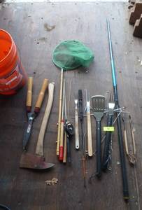 lot 94 image: Bucket with fishing poles, grilling tools, axe, clippers