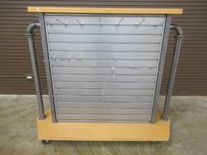 lot 61 image: Rolling Center Display Island With Slat Walls and Peg Hooks. Approximate Dimensions 60 x 24 x 52 Tall.