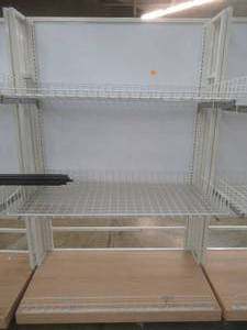 lot 73 image: Stationary Wall Display Rack With Adjustable Wire Basket Shelves And Wood Base. Approximate Dimensions 51 x 26 x 78 Tall.