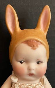 lot 429 image: Adorable Vintage Porcelain Doll with Rabbit Hat