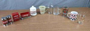 lot 280 image: Coca-Cola Memorabilia - Assorted Glasses and Mugs, Salt & Pepper Shakers, Cookie Jar, Sugar Packet Caddy, and Toothpick Holder M