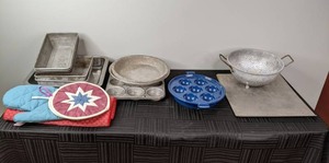 A Collection of Pie Dishes, Potholders, Blue Cast Iron Aebleskiver Pan and More