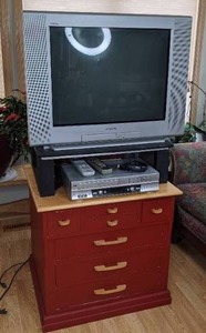 Sony Trinitron 27 TV with Remote on Stand, JVC VCRDVD Player with Remote, and Small Chest of Drawers