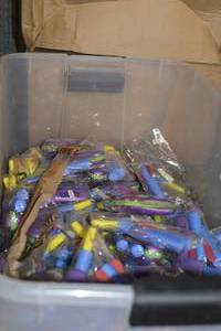 Container of foam guns and box of pens