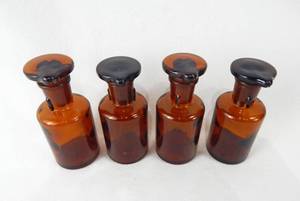 lot 62 image: Set of 4 Vintage Mercer Glass Works Merco 60 ML Amber Glass Flat Top Grooved Stopper Dropping Bottles