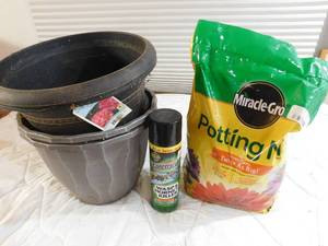 lot 29 image: 4 plastic planters, bee spray,and potting soil