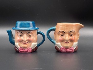 lot 411 image: Artone of England Two Faced Pitcher and Small Pitcher
