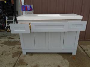 Everdean 48.5 x 18.75 vanity with top. Has flaw in right hand door as shown in pictures. Was bought to remodel bath but moved instead. As shown. THIS ITEM HAS A RESERVE.