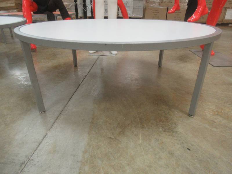 lot 157C image: Round Display Table, White Top, Approximate Dimensions 44 Dia x 15 12 Tall. Slight Scratch and Dent.