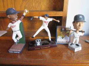 3 bobble heads and a card featuring...