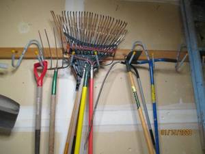 All yard tools hanging on garage wa...
