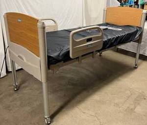lot 41 image: MSRP $5000 Hill-Rom Hillrom 100 Low Fully Adjustable Bed for Extended Care Communities Power UpDown HiVery Low Head UpDown & Knee UpDown With Remote Control Patient Pendant - Great Working Condition - Has Wear To Top Wood Footboard In Areas