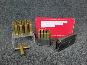 lot 3026 image: Lot of (14) 30-30 Brass Casings, (8) Blanks in an M1 Clip, and 1 Clip for Unknown Firearm