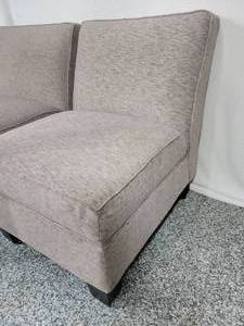 lot 26 image: A pair of fabric slipper chairs with wood feet.