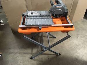 lot 40 image: RIDGID 9 Amp Corded 7 in. Wet Tile Saw with Stand, Customer return, Review all pictures