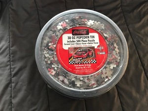 lot 143 image: Coca Cola Popcorn Tin Nascar Driving Your Thirst 4 Racing 500 Piece puzzle  Never been opened