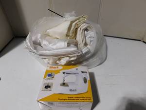 lot 242 image: Garbage bag of crme and white satin and mini sewing machine