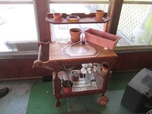 lot 21 image: Wood Planters cart with wheels on o...