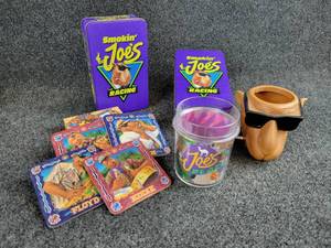 lot 2033 image: Lot of Joe Camel Memorabilia - Coasters, Can Koozie, Plastic Cup, (2) Tins