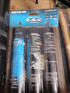 Box with a Grease Gun, a Mini Grease Gun a New Package of New 2 -4 -C Grease Tubes, Two New Mini Wire Brushes and an Outboard