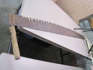 lot 230 image: Antique Large sized One-Man Cross Cut Collectors Logging Saw with wood handle and buck toothed blade. Has the perfect rustic cabin decor feel