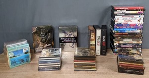 lot 294 image: Pile of CDs and DVDs Elton John, Keith Urban, 80s Pop Hits, Garth Brooks, Mozart, Bach, Beethoven, and The Transformers The Original Complete Series, Lost, True Blood, Oceans Eleven, Made of Honor, Big Fat Liar, Little Rascals, Shrek, Etc. X